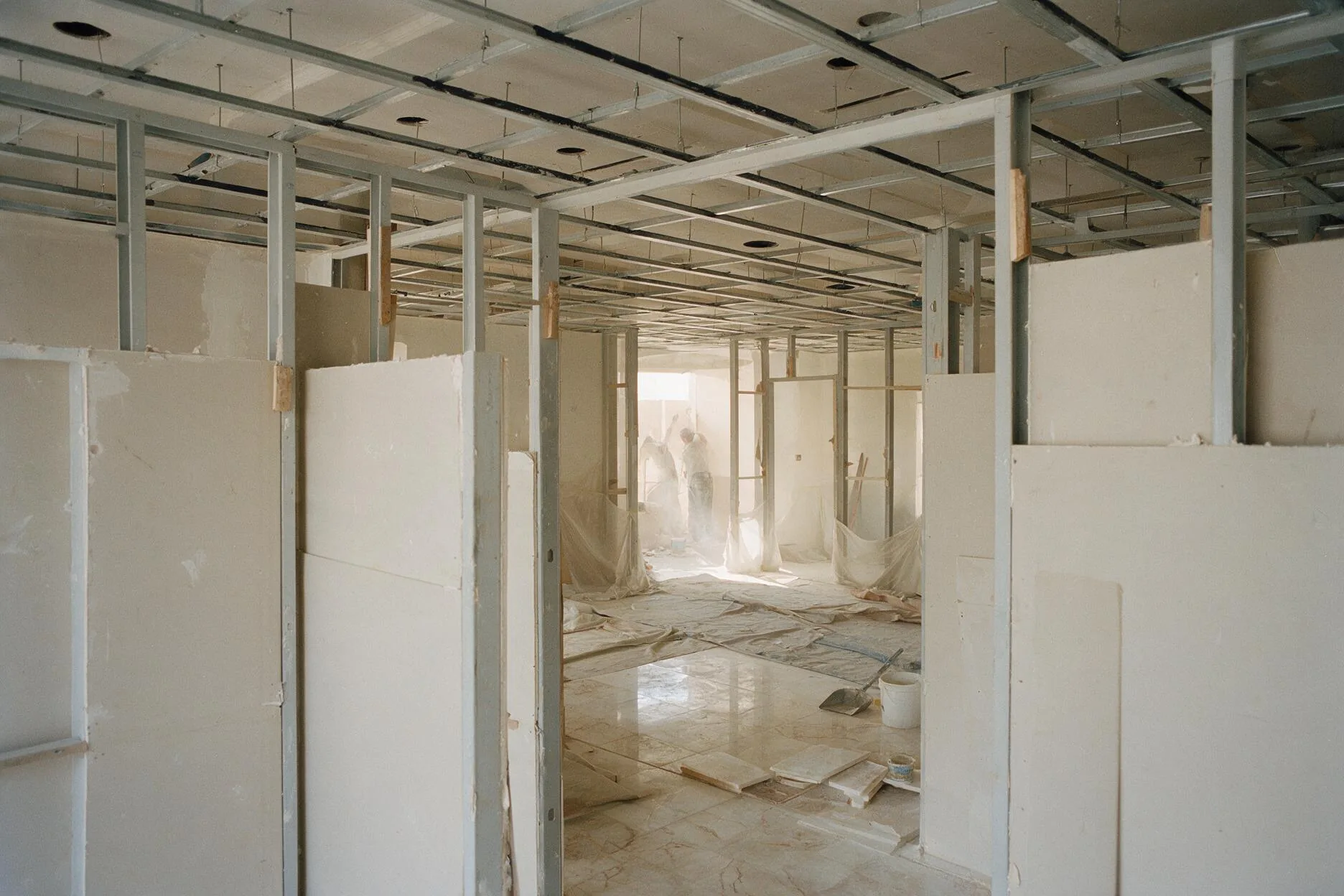 Gypsum board partitions and suspended ceiling grid installed during interior fit-out of a Saudi residential building